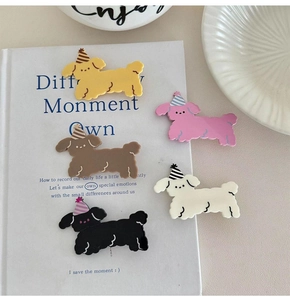 Set of five colorful matte resin puppy hair clips on a decorative book background