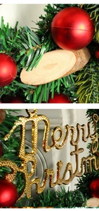 Detailansicht des Weihnachtskranzes mit roten Kugeln, Holzscheiben und Merry Christmas
