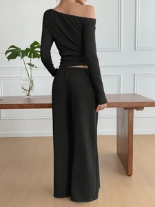 Back view of black off-shoulder long sleeve top and wide-leg trousers with pleated texture
