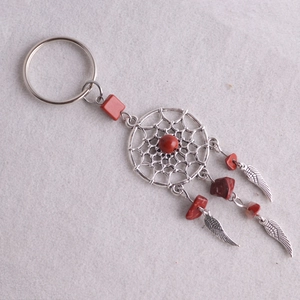Detalle del llavero atrapasueños bohemio con piedras rojas y plumas plateadas