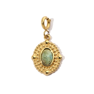 Detail of a vintage gold-plated oval pendant with a light green natural stone setting