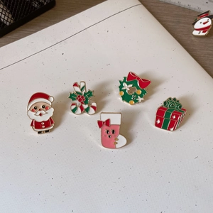 Christmas enamel pin set featuring Santa, reindeer and snowman on a white surface