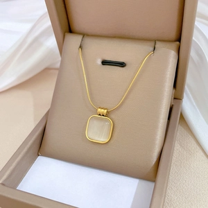 Detailed close-up of a square opal pendant on a gold snake chain in a premium jewelry box