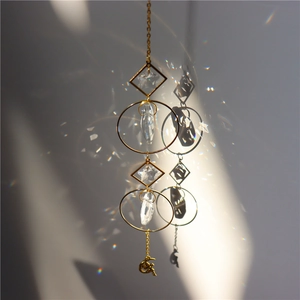Detailed view of moon crystal sun catcher casting rainbow light on a grey wall