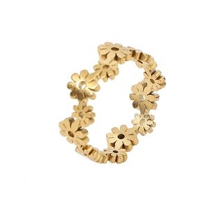 Detail showing the intricate daisy flower cutouts and golden 18k finish of the titanium ring