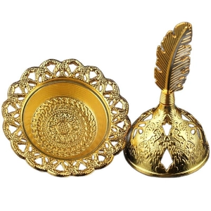 Golden Arabic alloy incense burner with hollow pattern and feather handle on white base