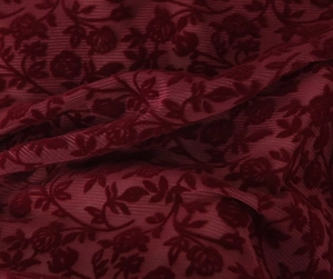 Detailed view of dark burgundy flocked lace fabric with elegant 3D rose flower patterns