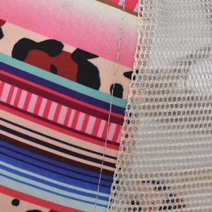 Detail of patterned fabric stitching with breathable white honeycomb mesh on a baseball cap