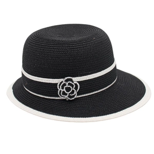 Detail of black straw hat with white decorative band and elegant camellia bead ornament