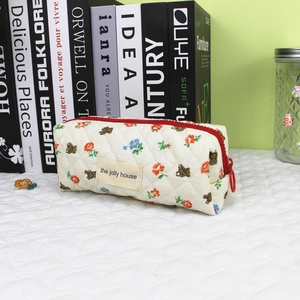 Detail of cream quilted cotton pencil bag with vintage bear and flower prints and red zipper