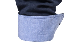 Close-up of navy blue shirt cuff featuring light blue contrast lining and fine stitching