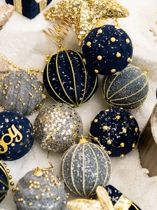 Detailed view of assorted blue and gold velvet Christmas ornaments with glitter patterns