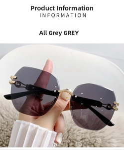 Detalle de gafas de sol grises sin montura con varillas doradas y motivos griegos