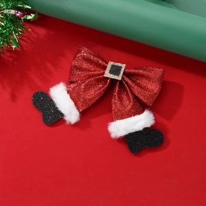 Detail of red sequined Christmas bow hair clip with Santa belt and white faux fur trim
