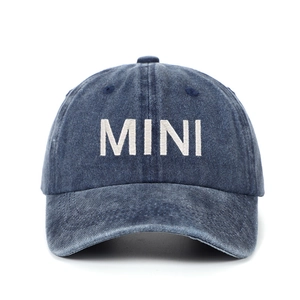 Detailed close-up of MINI embroidery on washed navy blue denim cotton baseball cap