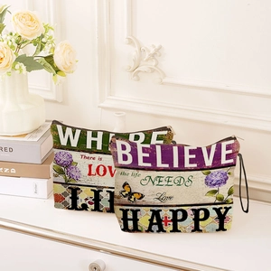 Blumen-Canvas-Tasche mit 'Believe' und 'Happy' Text auf vintage Tischhintergrund