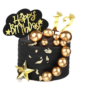 Boules dorées et décoration de gâteau Happy Birthday noire sur un gâteau noir