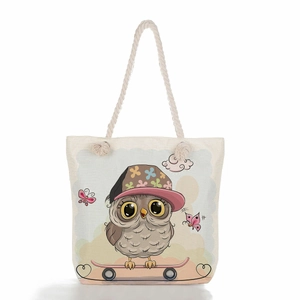Detail of a beige canvas tote bag with hemp rope handles and cute cartoon owl print