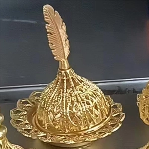 Détail d'un encensoir doré du Moyen-Orient avec poignée en plume et dôme évidé