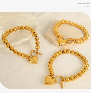 Detailed macro of gold beaded bracelet set with heart charms and OT toggle closures