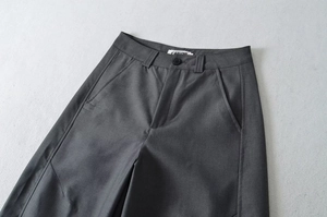 Detail der dunkelgrauen weiten Hose mit Taillenlaschen, Taschen und feiner Nahtstruktur