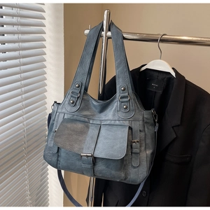 Detailed shot of a vintage blue-grey leather tote bag with silver hardware and straps