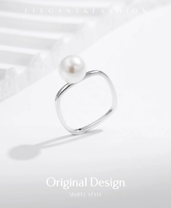Detailed close-up of a silver square pearl ring with elegant minimalist lighting