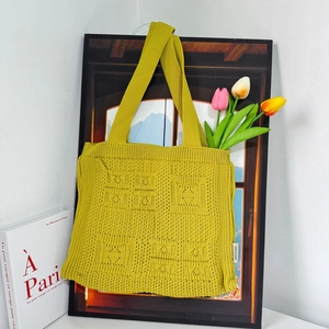 Detail of mustard yellow knit tote bag with square texture and tulip floral decor