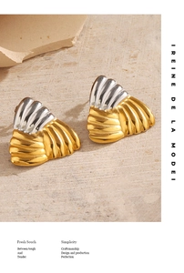 Gros plan de boucles d'oreilles géométriques bicolores avec texture rainurée sur pierre