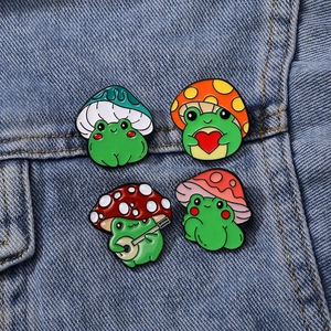 Set of four cute cartoon frog enamel pins with mushrooms and guitars on denim fabric