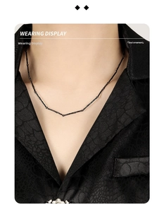 Detail of S925 silver necklace with black rock texture on model wearing black shirt