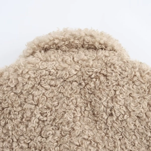 Detailed macro view of curly fleece texture and oatmeal colored faux fur on jacket