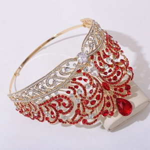 Macro shot of gold wedding tiara featuring intricate red crystals and teardrop gemstones