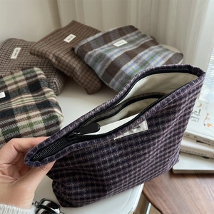 Detailed interior of vintage plaid wool makeup bag showing lining and storage space
