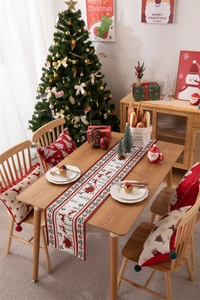 Detailed Christmas table runner with reindeer and snowflake patterns on a dining setup