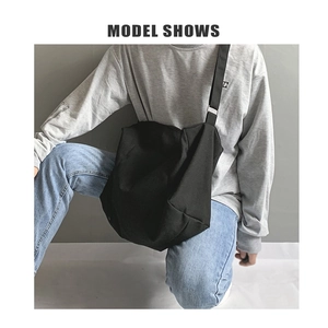 Detail of black large canvas crossbody bag showing spacious capacity and slouchy style