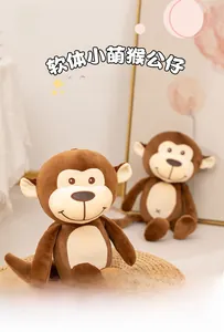 Close-up of soft plush monkey dolls featuring brown fur and white faces on a woven mat