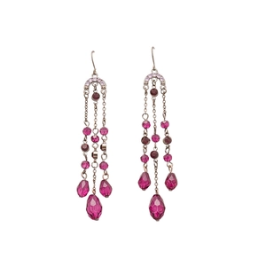 Boucles d'oreilles vintage avec cristaux magenta et longs pompons argentés sur fond blanc