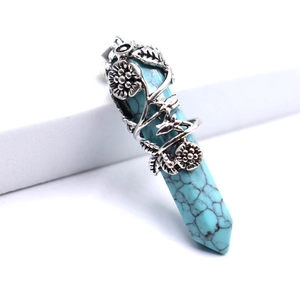 Détail macro du pendentif hexagonal en pierre bleue avec libellule et fleurs argentées