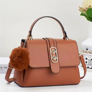 Caramel faux leather handbag for women with gold clasp and plush decorative charm