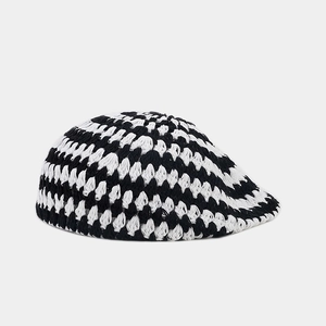 Détail de la casquette gavroche tricotée main à carreaux noirs et blancs au crochet