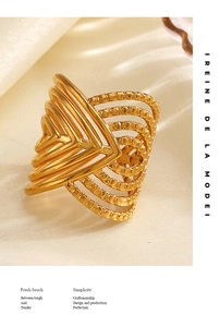 Macro shot of 18K gold plated multi-layer crossover ring on cream silk background