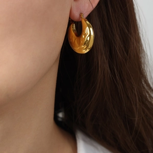 Elegant gold plated titanium steel hoop earrings with embossed antler texture on model
