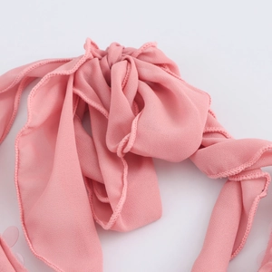 Détail de la robe licou à paillettes roses montrant le mousseline et les bords roulés