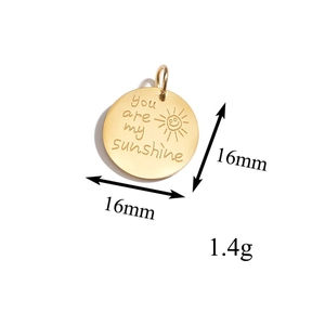 Vue macro d'un pendentif soleil doré 16mm montrant le poids 1,4g et la taille