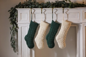 Close-up of deep green and ivory knitted Christmas stockings with cable knit texture