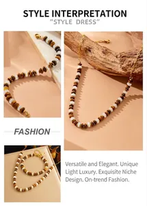Detail of tiger eye and white bead necklace set with gold stainless steel chain