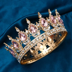 Detailed close-up of golden bridal crown with pink waterdrop gemstones on blue satin