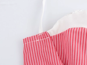 Detail shot of red and white striped dress showing white trim and thin shoulder straps