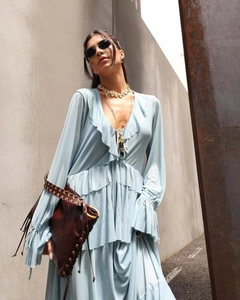 Detail of light blue V-neck maxi dress with ruffled layers and a matching clutch bag